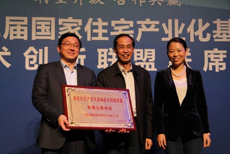 住建部科技与产业化发展中心主任杨榕(中)为 中国建材股份副总裁、北新建材董事长王兵(左)授牌