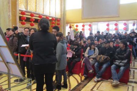 图为：现场置业者排队办理手续