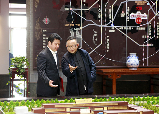 红木文化新城营销总经理胡颖向王刚介绍项目进展
